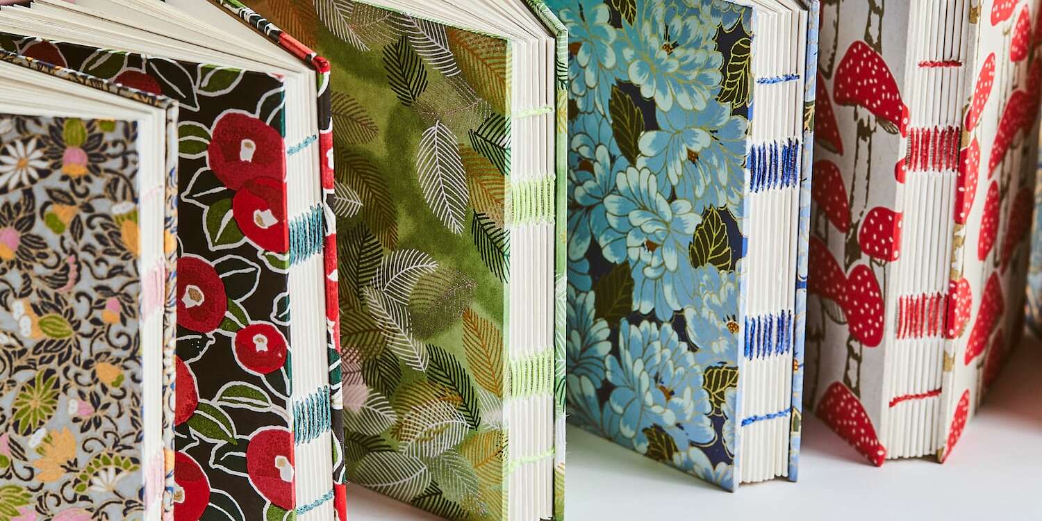 Instruktor demonstrujący klejenie grzbietu książki za pomocą pędzla i kleju