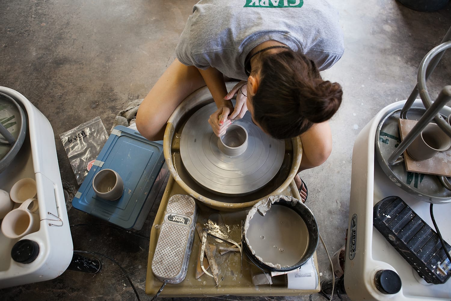 Samodzielny uczestnik toczy wazon na kole garncarskim w skupieniu