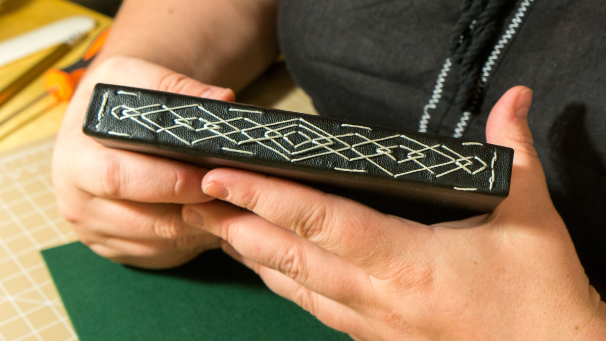 Stos kolorowych skórzanych arkuszy i narzędzi do cięcia na stole warsztatowym