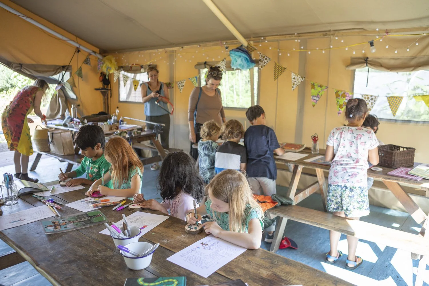 Artysta składający kolorowe kawałki szkła w witrażową mozaikę przy stole z narzędziami