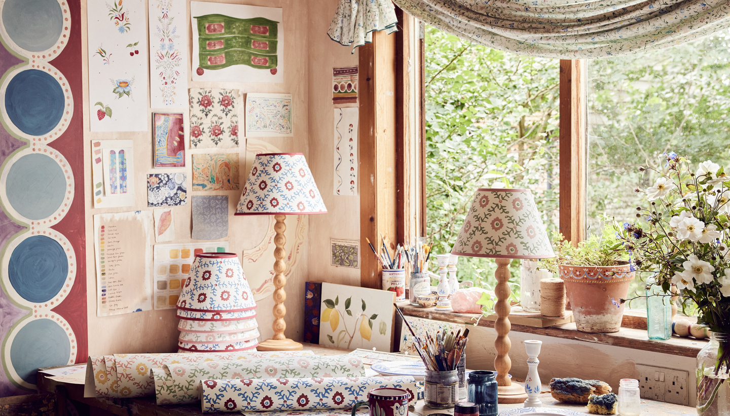 Kolorowe farby pędzle i dekoracyjnie pomalowane wazy talerze na stole w studiu artystycznym