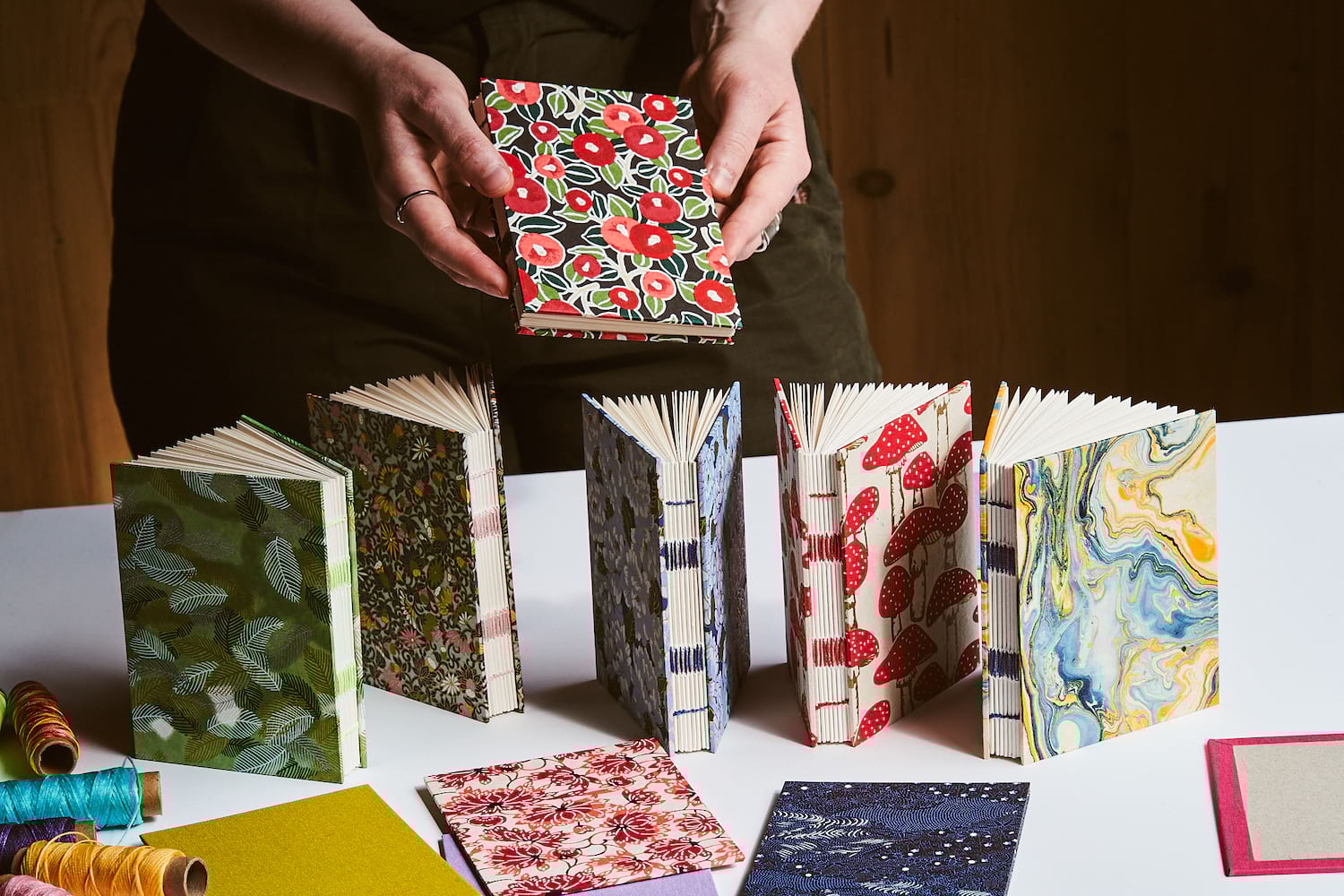 Grupa uczestników kursu przy stole z nożami, linijkami i papierem do cięcia