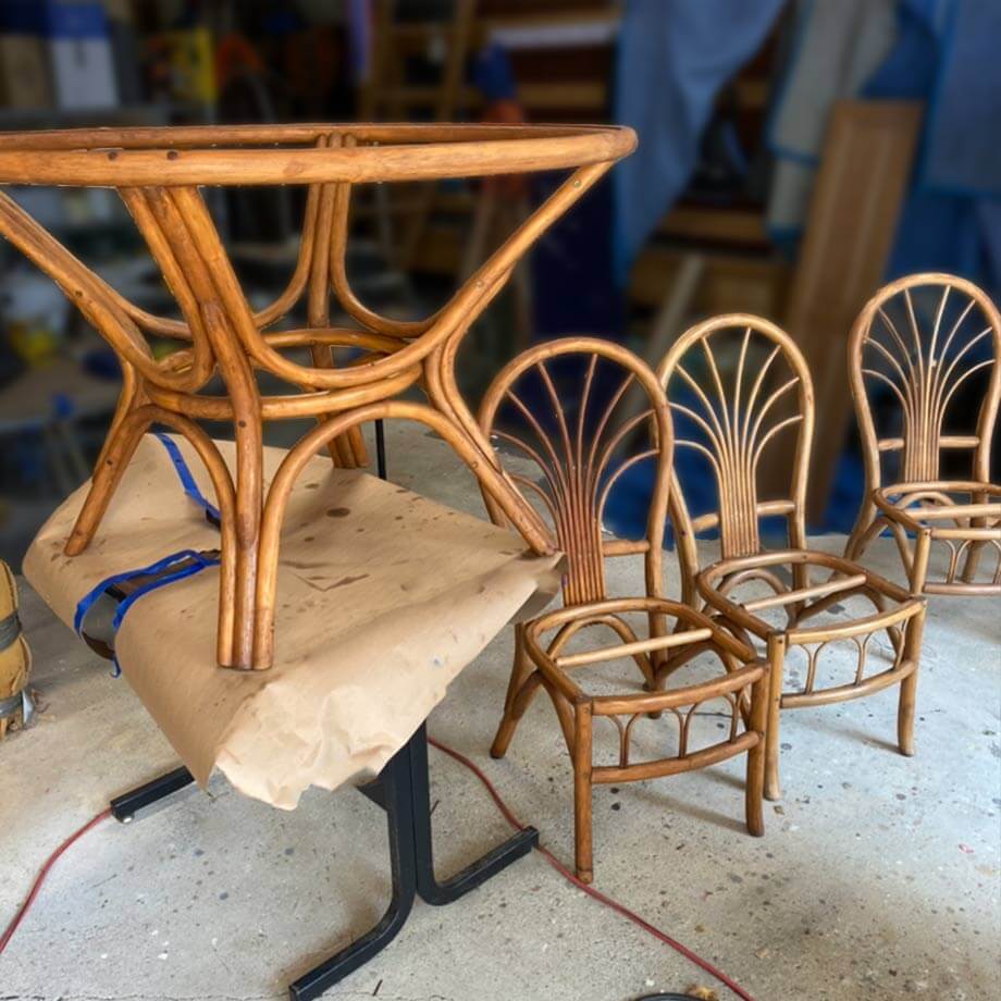 doświadczony renowator w fartuchu pracuje nad antycznym stołem w jasnym warsztacie