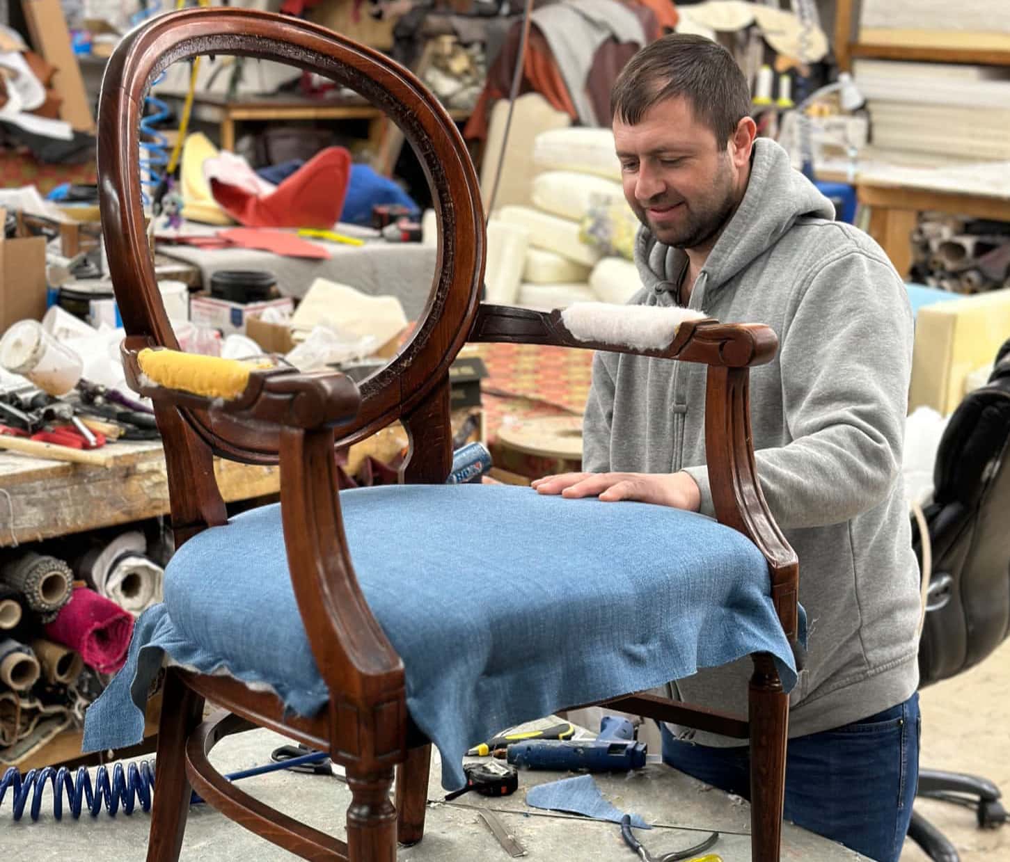 renowator czyści srebrną wazę miękką szczotką i specjalnym płynem w misce